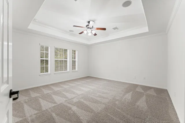 an empty room with windows and ceiling fan view