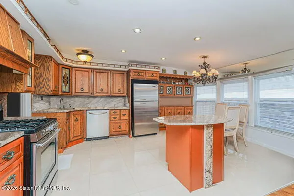 a kitchen with stainless steel appliances granite countertop a stove and more cabinets