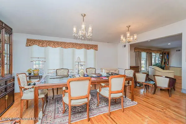 a view of a dining room with furniture a chandelier and wooden floor