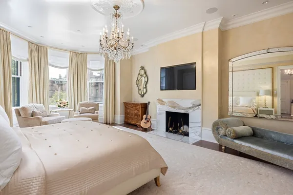 a spacious bedroom with a bed and a fireplace