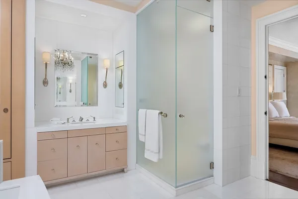 a en suite bathroom with a double vanity sink a large mirror and a shower