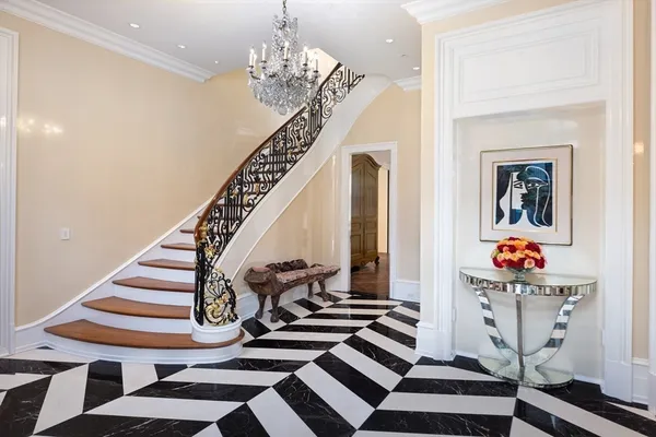 a view of a hallway with entryway and chandelier