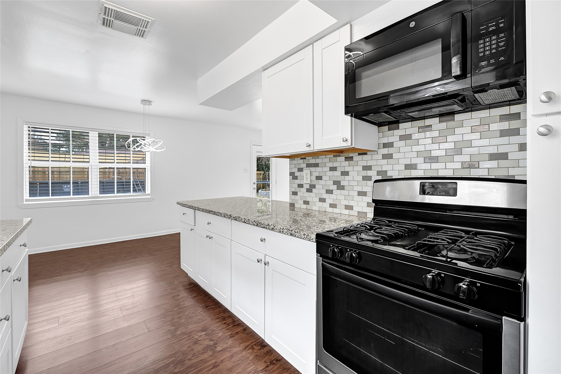 2016 South Houston Road Pasadena, TX 77502 - Photo 10 of 24 a kitchen with stainless steel appliances wooden cabinets stove and microwave