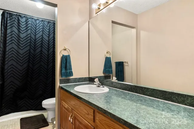 a bathroom with a granite countertop sink toilet and a mirror