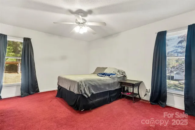 a spacious bedroom with a bed and a window