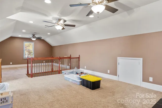 a view of an empty room with window and a ceiling fan