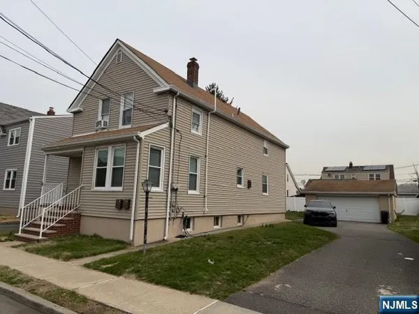 a view of a white house next to a yard