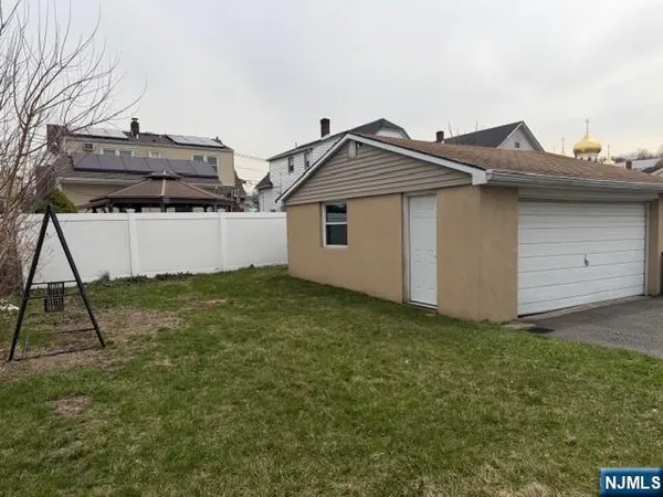 a view of a house with a small yard and wooden fence