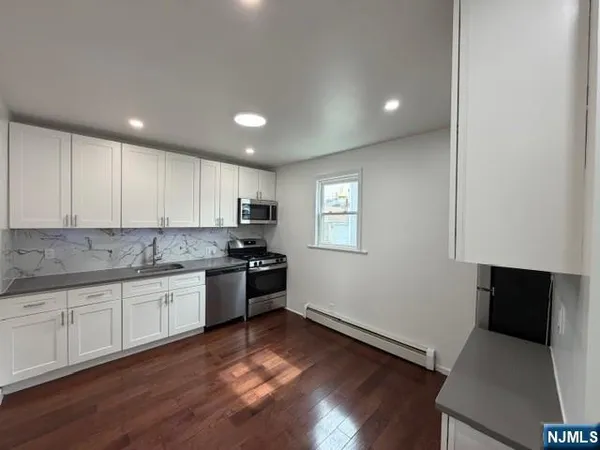 a kitchen with granite countertop a sink and a stove top oven