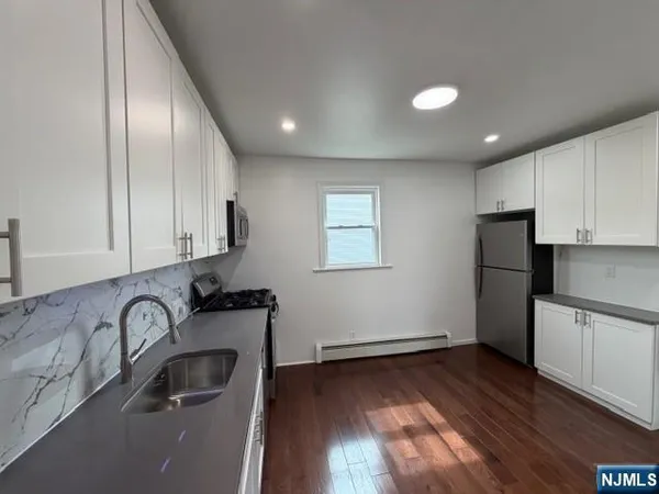 a view of a kitchen with sink and refrigerator