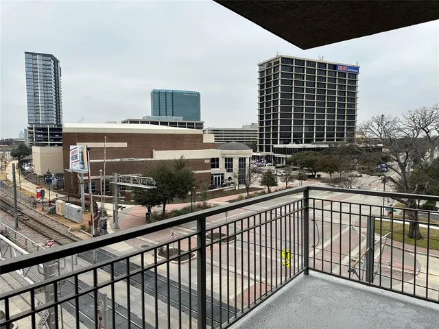 a view of balcony with a couple of cars parked in front of it