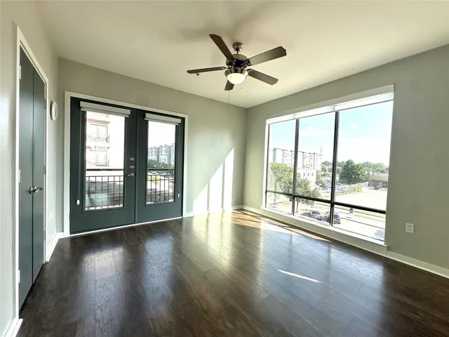 an empty room with wooden floor and windows