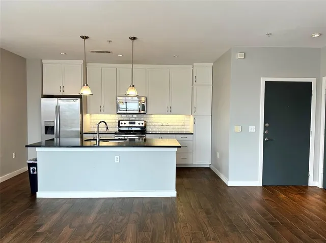 a kitchen with kitchen island a sink a stove a refrigerator and island