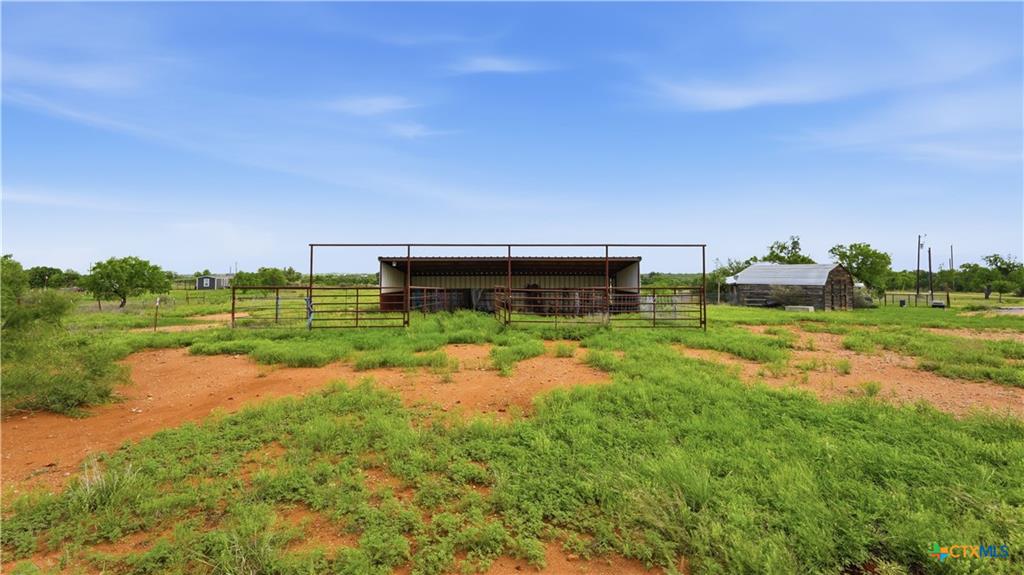 127 Offer Llano, TX 78643 - Photo 30 of 40 Expansive open land with a metal-roofed animal shelter featuring steel pipe fencing
