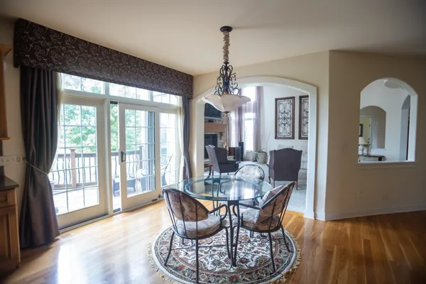a dining room with furniture a chandelier and wooden floor