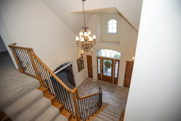 a view of a hallway with wooden floor and staircase