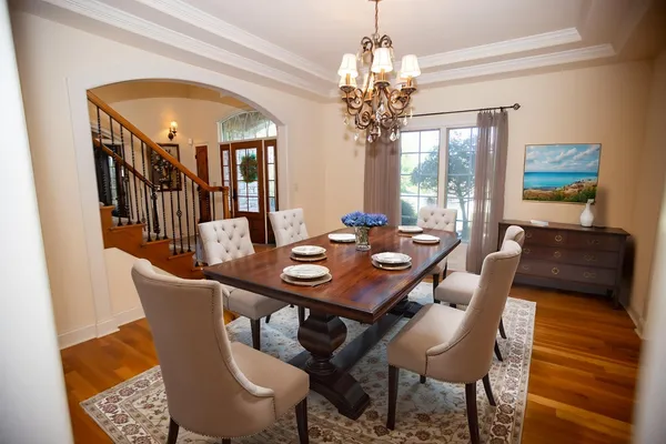 a view of a dining room with furniture a chandelier and wooden floor