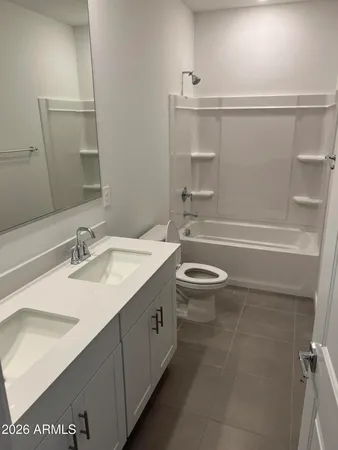 a bathroom with a granite countertop sink a toilet a mirror and shower