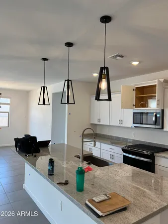 a kitchen with stainless steel appliances granite countertop a sink a stove and a wooden floor