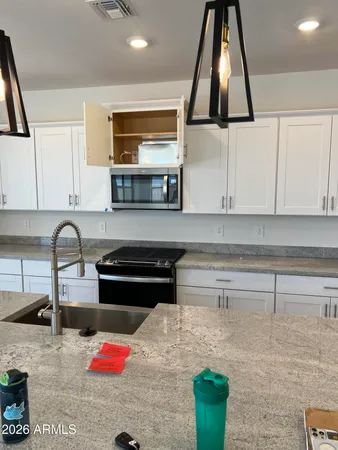 a kitchen with stainless steel appliances kitchen island granite countertop a sink and a stove