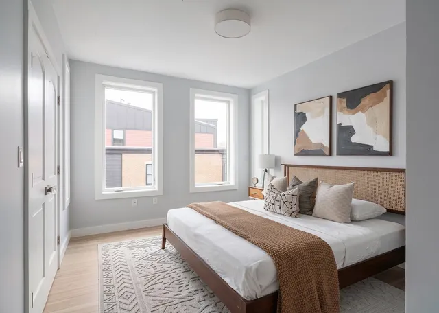 a bedroom with a bed and a painting on the wall