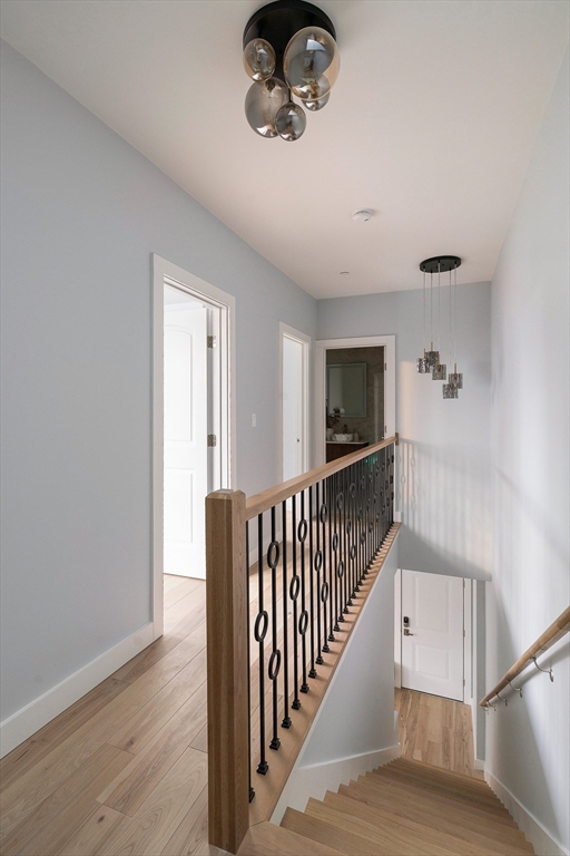 181 Maverick Street, Unit PH Boston, MA 02128 - Photo 18 of 20 a view of a hallway with wooden floor and staircase