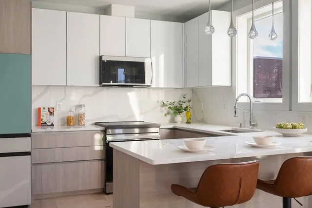 a kitchen with stainless steel appliances granite countertop a sink stove and microwave
