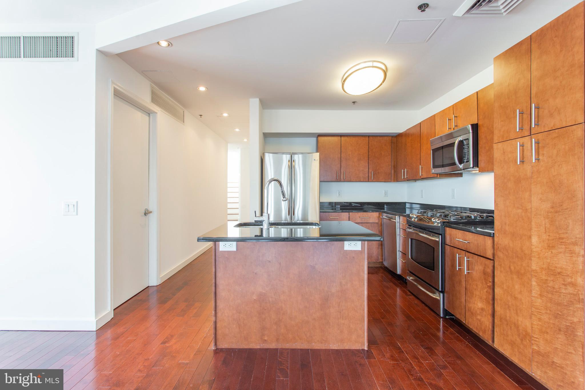 22 North Front Street, Unit PH1 Philadelphia, PA 19106 - Photo 11 of 42 a kitchen with stainless steel appliances granite countertop a stove a sink and a refrigerator with wooden floor