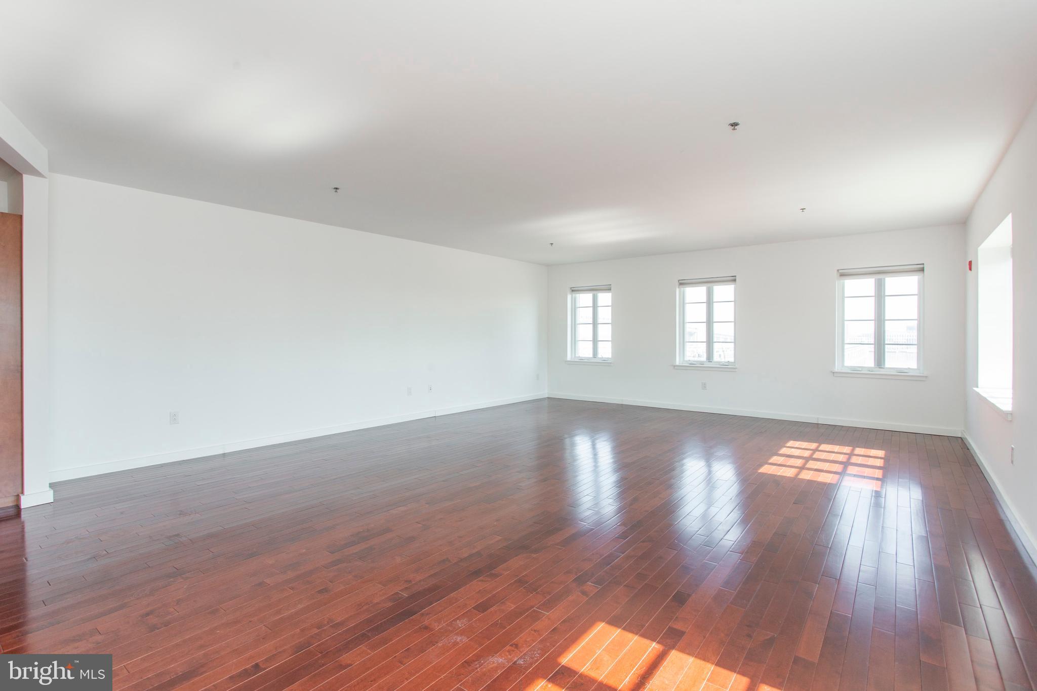 22 North Front Street, Unit PH1 Philadelphia, PA 19106 - Photo 3 of 42 an empty room with wooden floor and windows