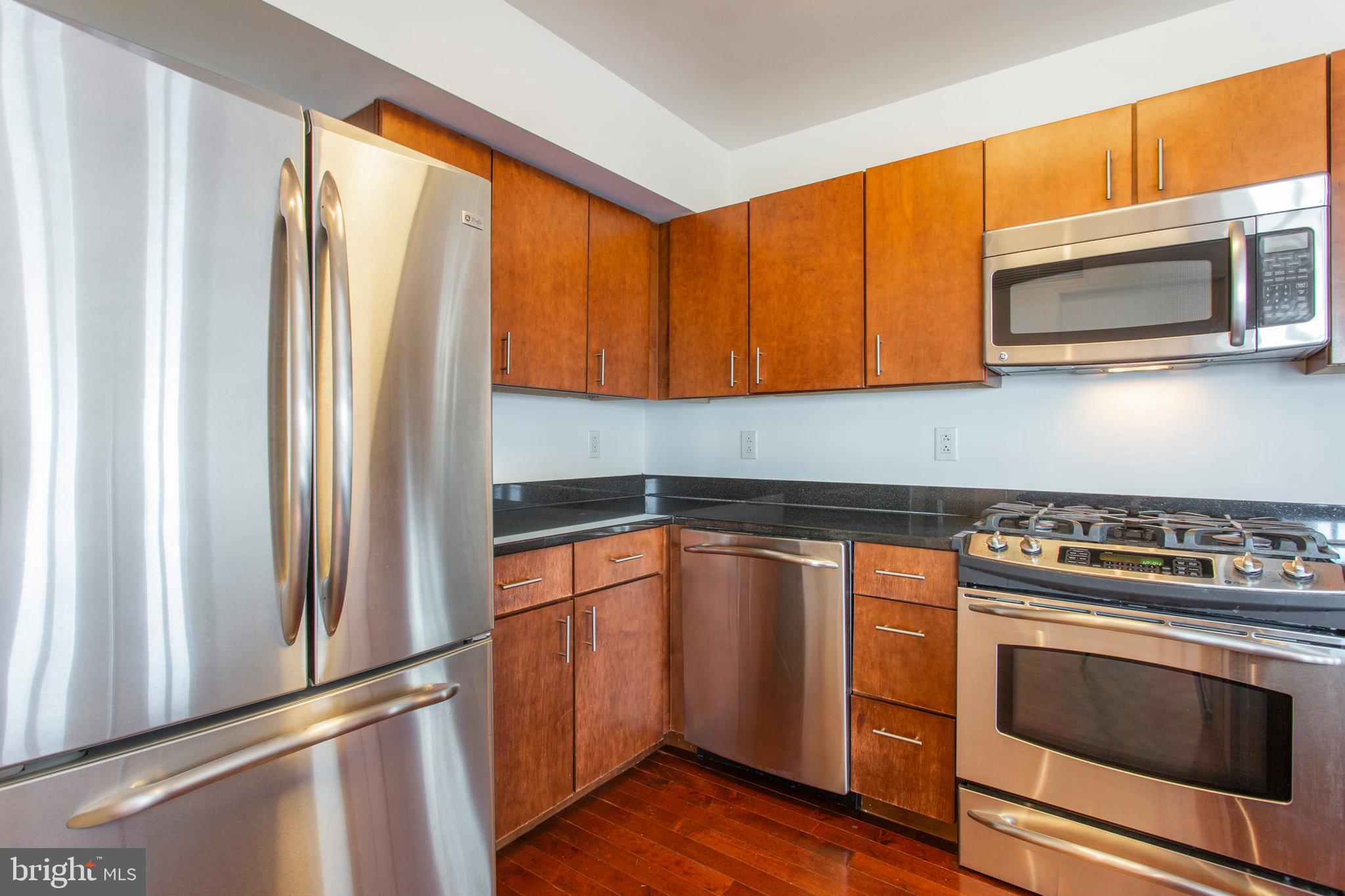 22 North Front Street, Unit PH1 Philadelphia, PA 19106 - Photo 10 of 42 a kitchen with stainless steel appliances granite countertop a stove a microwave and a refrigerator