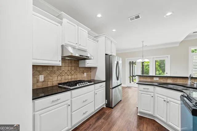a kitchen with granite countertop white cabinets and white appliances