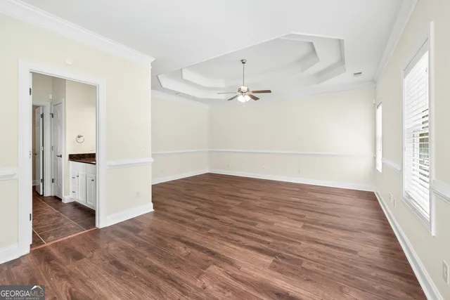 a view of empty room with wooden floor and window