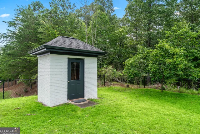 a backyard of a house with plants and large tree