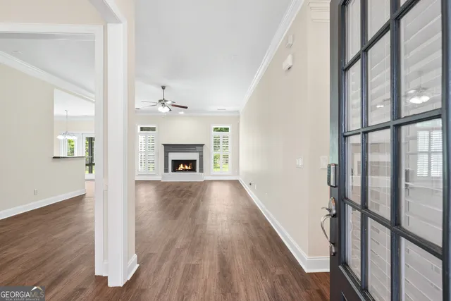 wooden floor in an empty room with a fireplace and a window