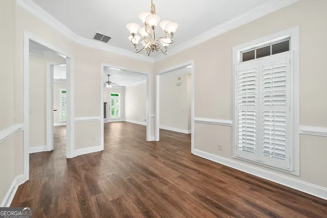 a view of a hallway with wooden floor and a chandelier