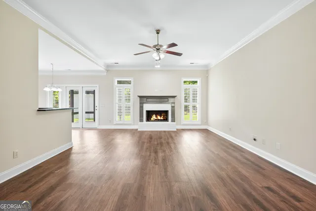 an empty room with fireplace wooden floor and windows