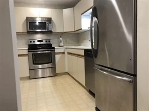 a kitchen with stainless steel appliances a refrigerator stove and microwave