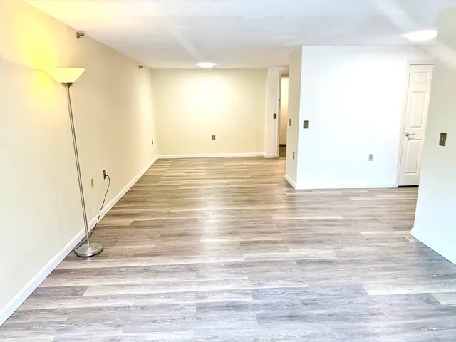 a view of a room with wooden floor and a bathroom view