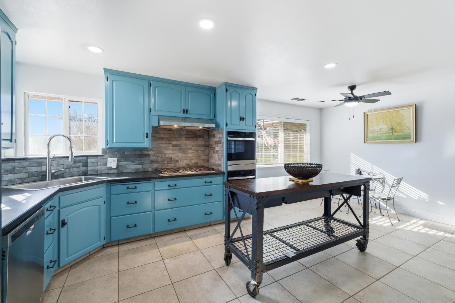 2938 North Trinity Avenue Kerman, CA 93630 - Photo 11 of 38 a kitchen with granite countertop a sink cabinets and stainless steel appliances