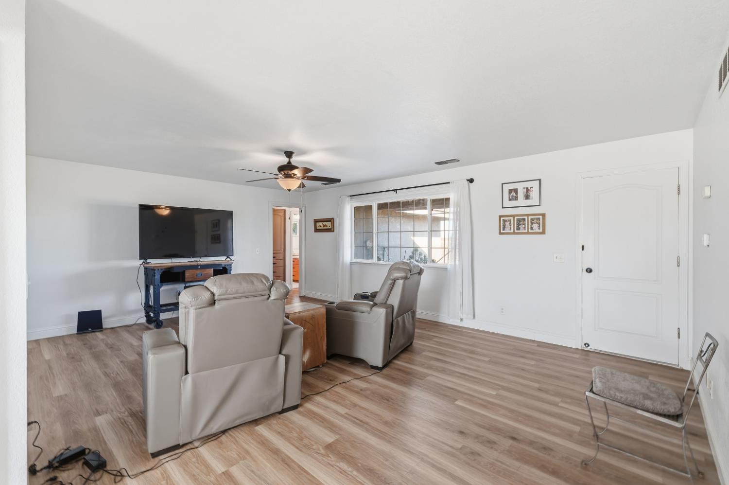 2938 North Trinity Avenue Kerman, CA 93630 - Photo 12 of 38 a living room with furniture and a flat screen tv