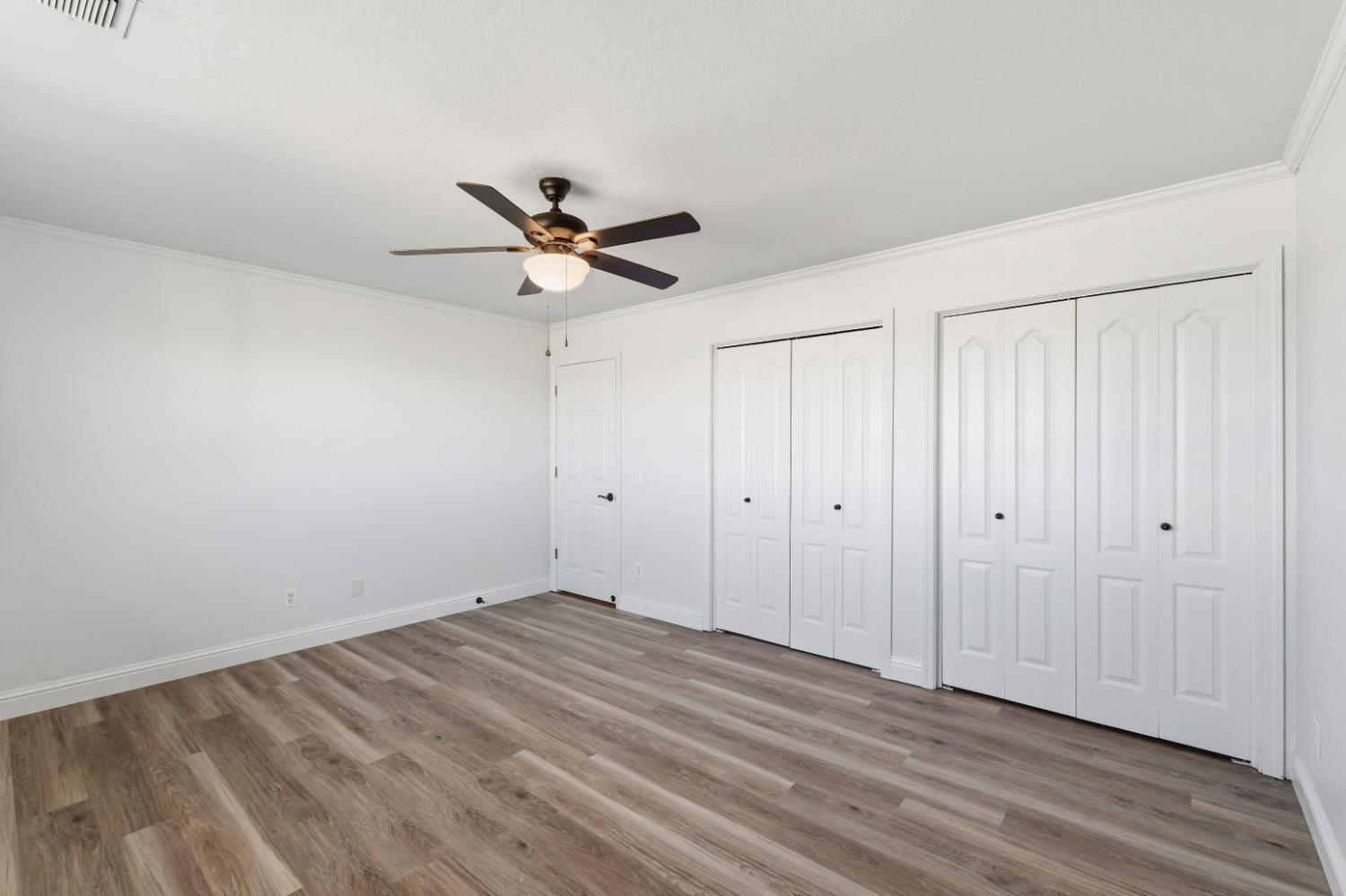 2938 North Trinity Avenue Kerman, CA 93630 - Photo 16 of 38 a view of a room with wooden floor and a ceiling fan