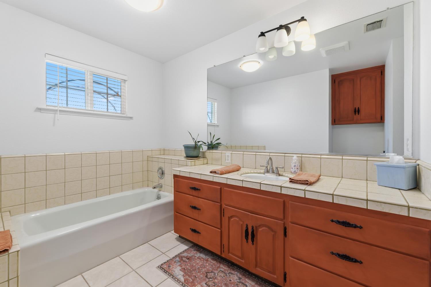 2938 North Trinity Avenue Kerman, CA 93630 - Photo 18 of 38 a bathroom with a tub sink and mirror