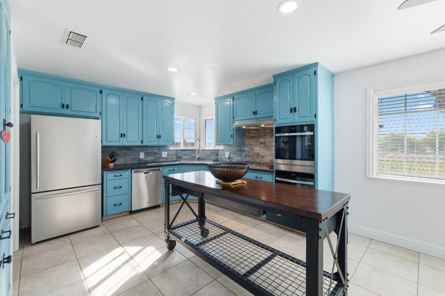 2938 North Trinity Avenue Kerman, CA 93630 - Photo 10 of 38 a kitchen with a refrigerator a stove a sink and a cabinets