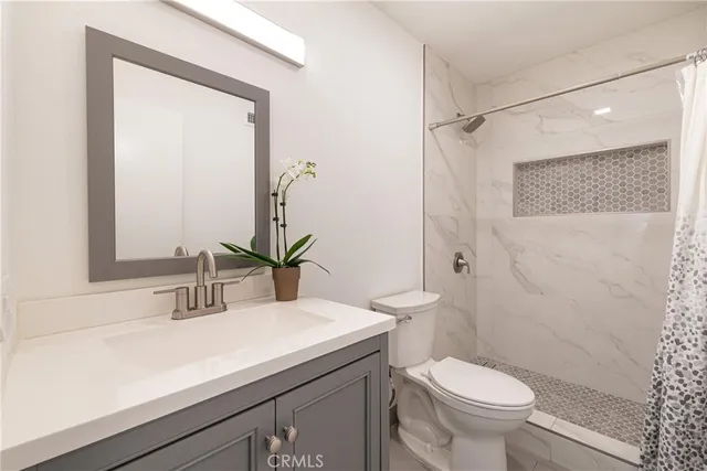 a bathroom with a sink a toilet a shower and a mirror