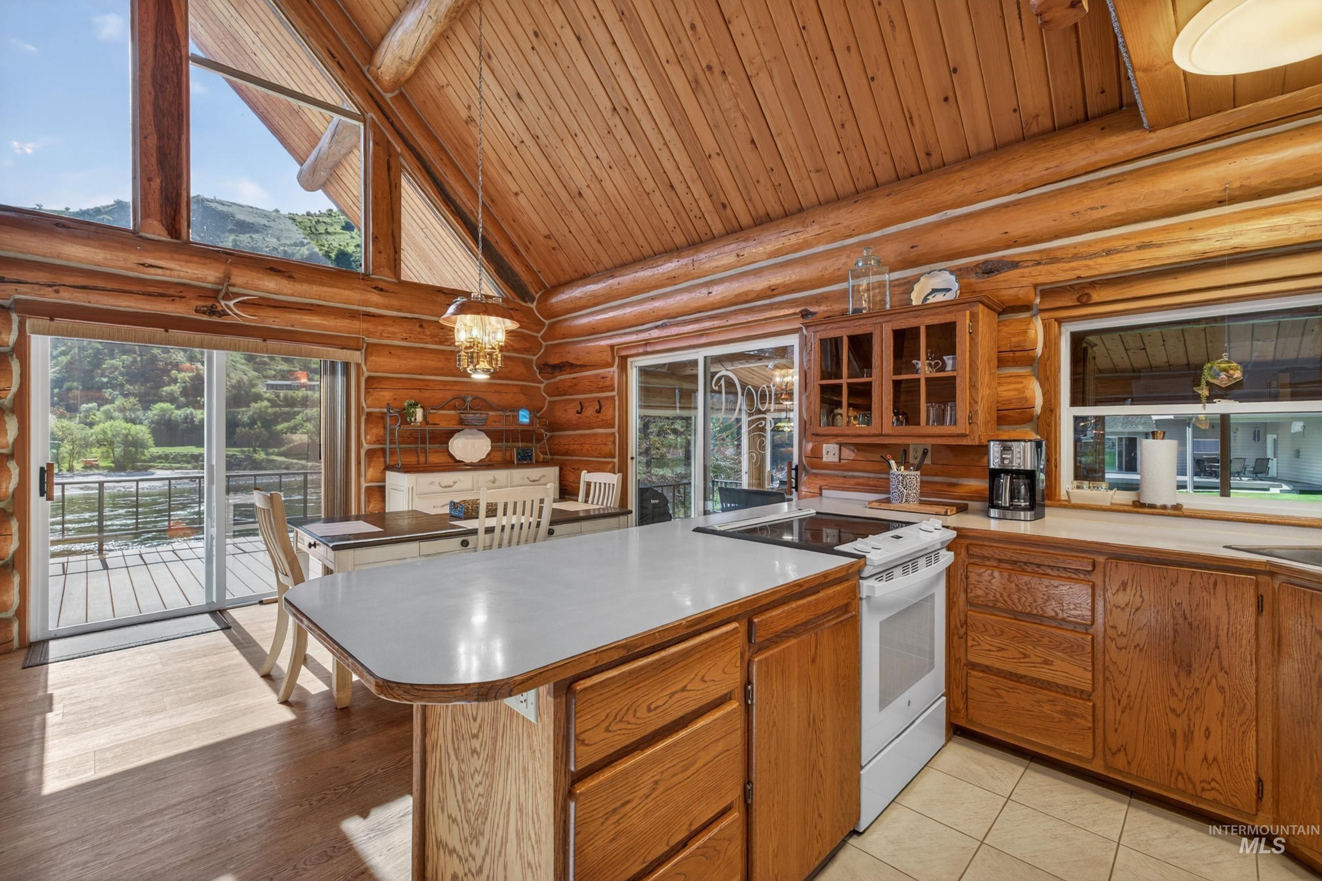 215 Doumecq Road White Bird, ID 83554 - Photo 11 of 50 Log cabin interior featuring a vaulted wood-plank ceiling and exposed log beams