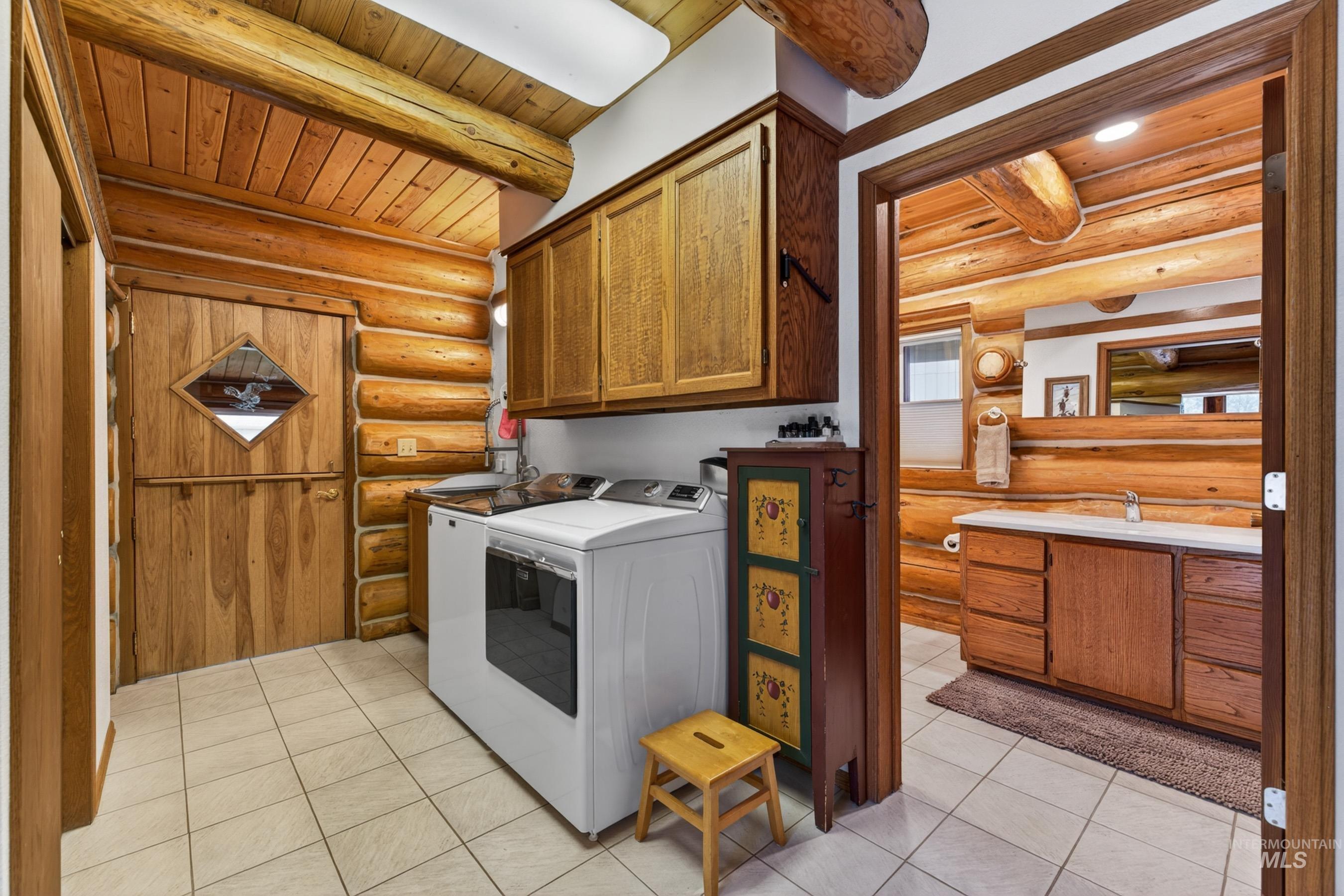 215 Doumecq Road White Bird, ID 83554 - Photo 18 of 50 Log cabin interior featuring a dutch door with a diamond window, wood-finish wall paneling, and a tiled floor