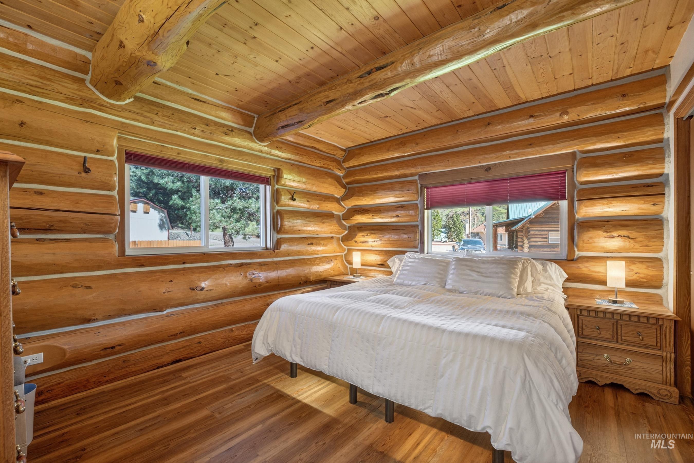 215 Doumecq Road White Bird, ID 83554 - Photo 20 of 50 Log cabin interior featuring exposed log walls, wood-finish flooring, and a wood plank ceiling with exposed beams