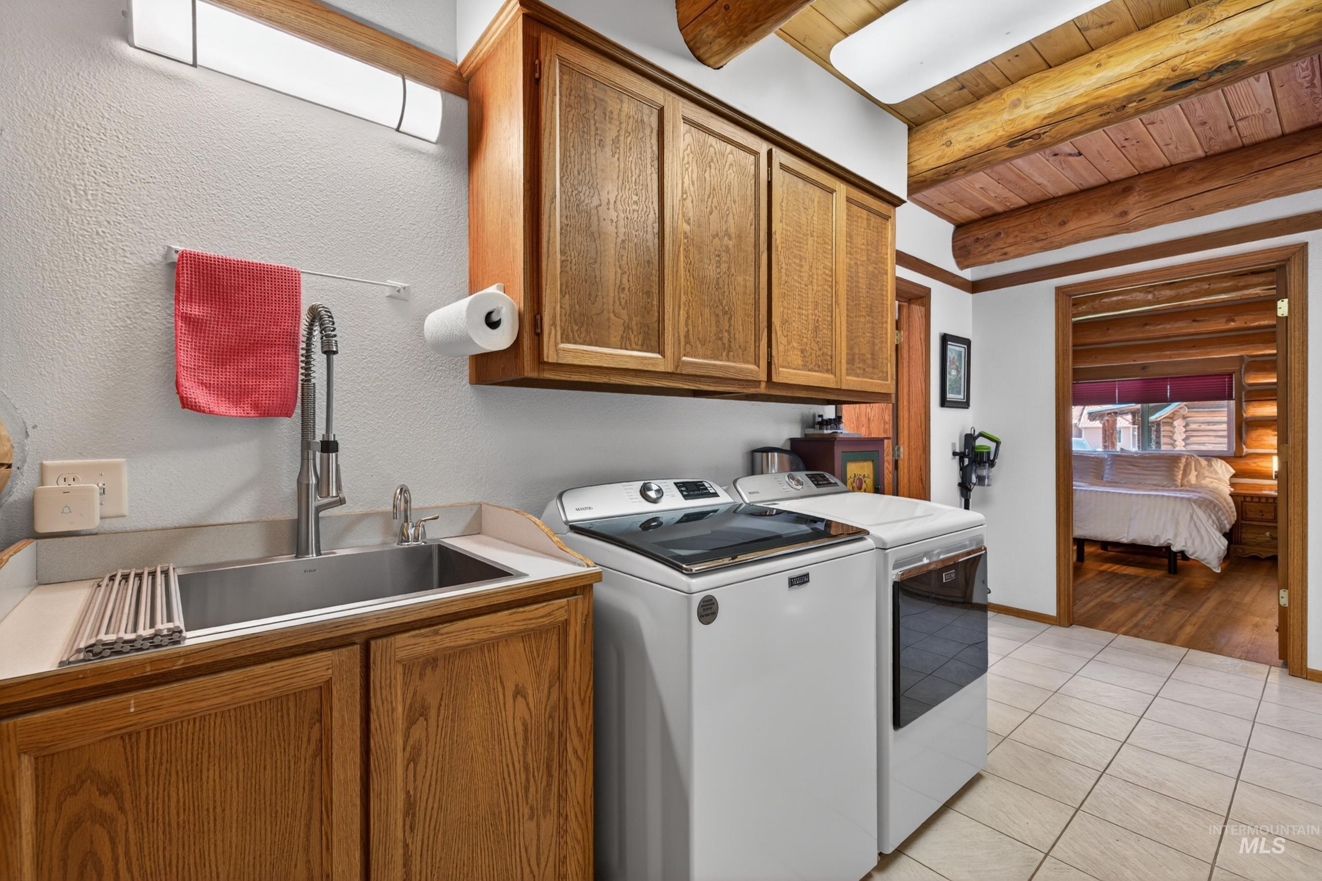 215 Doumecq Road White Bird, ID 83554 - Photo 21 of 50 Utility room featuring a stainless steel sink, wood cabinetry, and tiled flooring