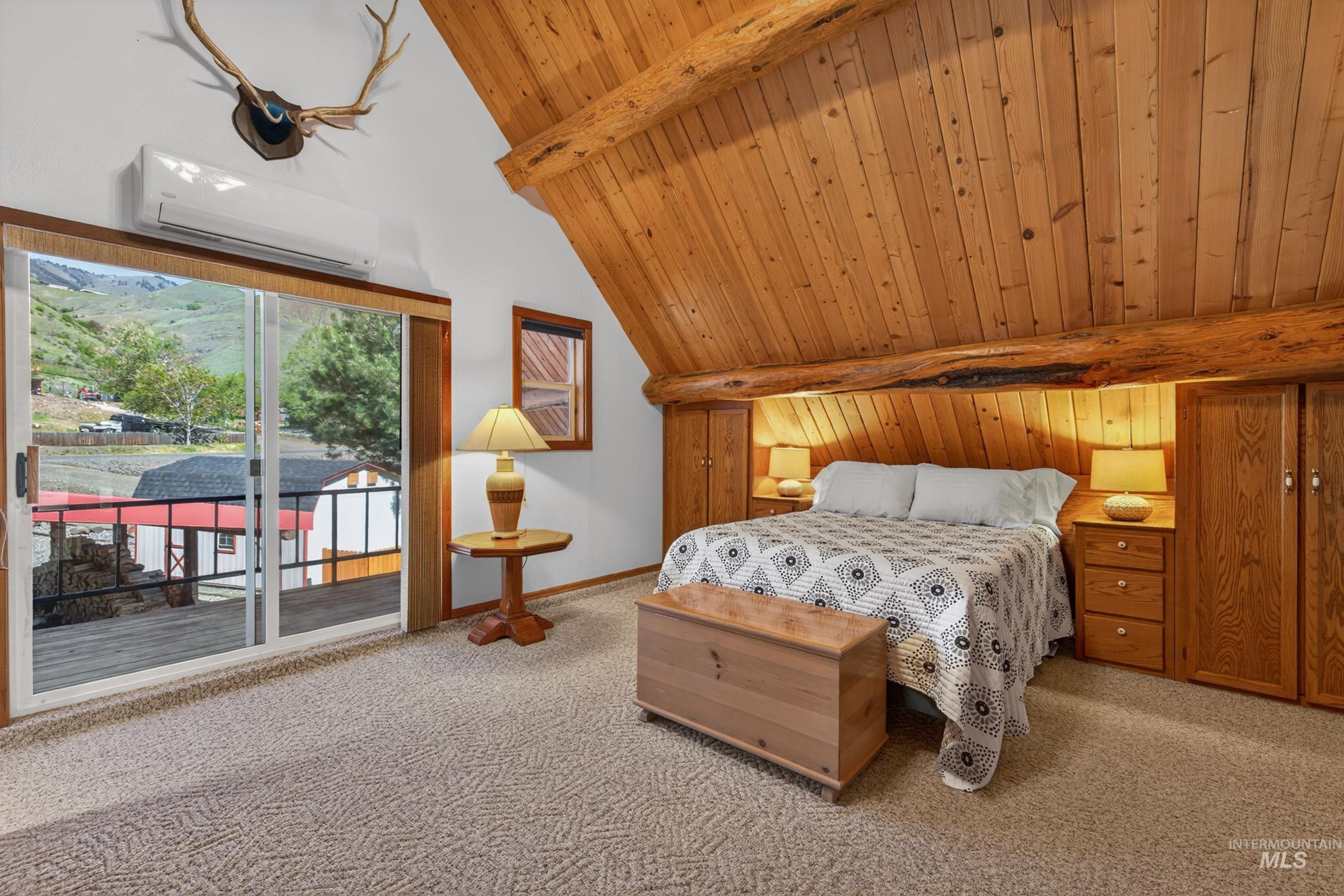 215 Doumecq Road White Bird, ID 83554 - Photo 25 of 50 Sliding glass door opening to a deck, featuring a wood-planked vaulted ceiling, built-in wooden cabinetry, and wall-mounted climate control