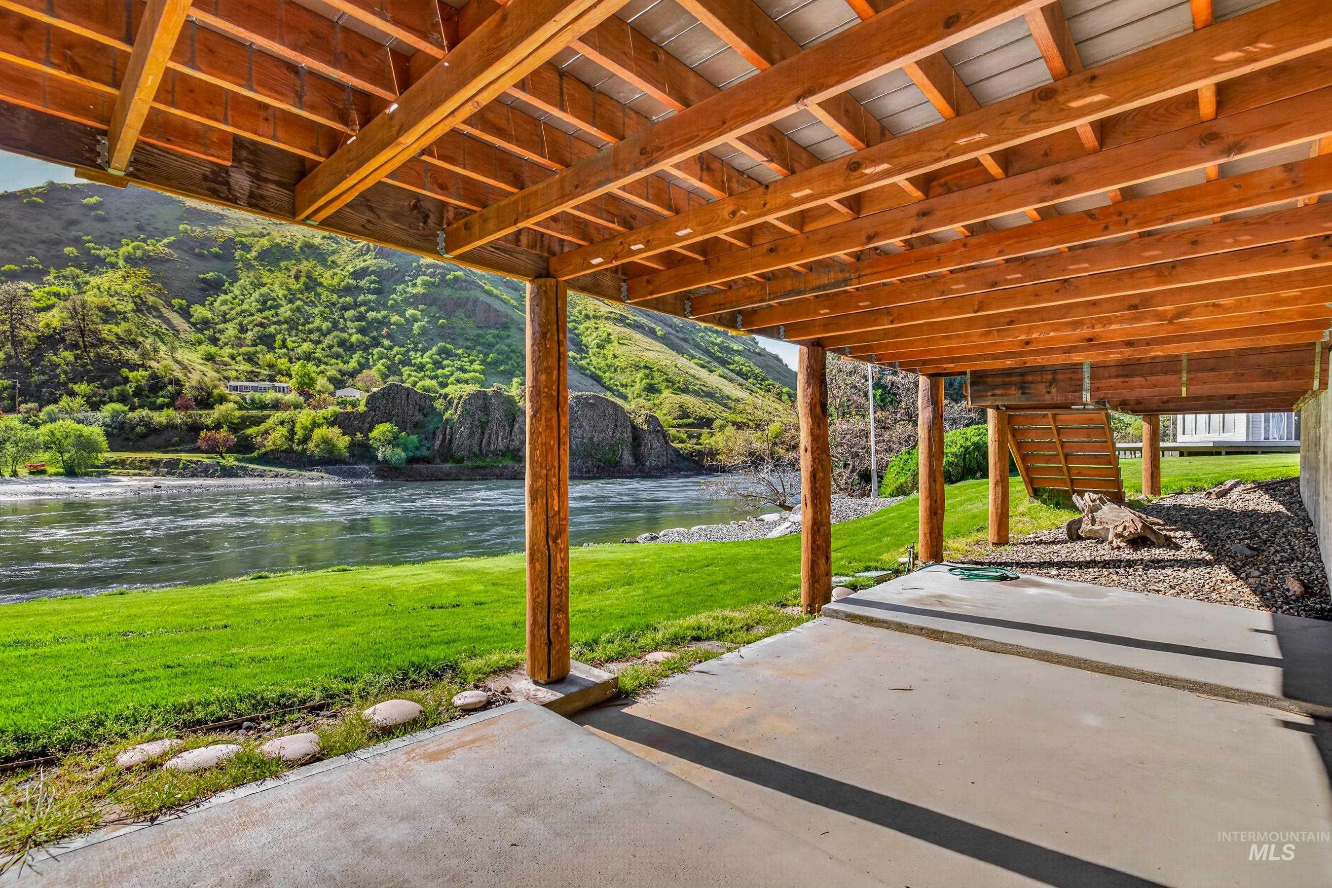 215 Doumecq Road White Bird, ID 83554 - Photo 31 of 50 Lower-level concrete patio featuring wood-finish support beams and an exposed wood-finish ceiling